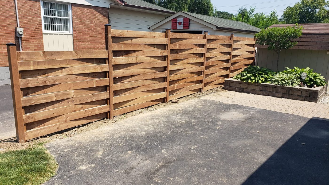 Horizontal cedar fence along a driveway